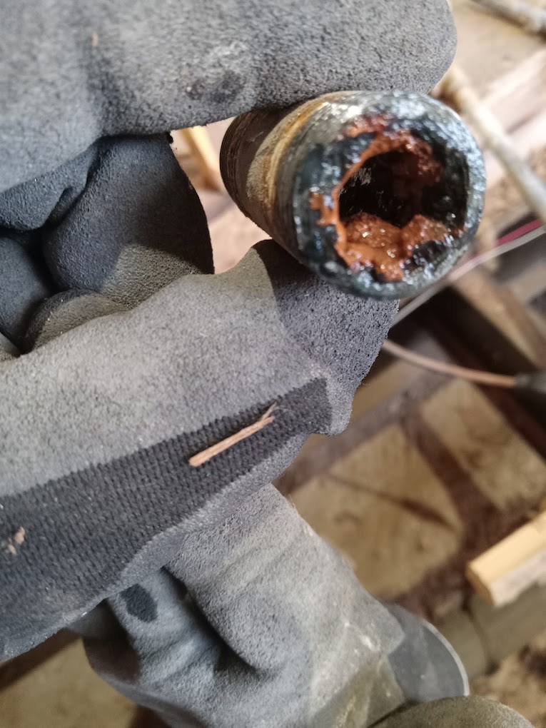 Corroded pipe cross-section showing heavy buildup — removed during repair