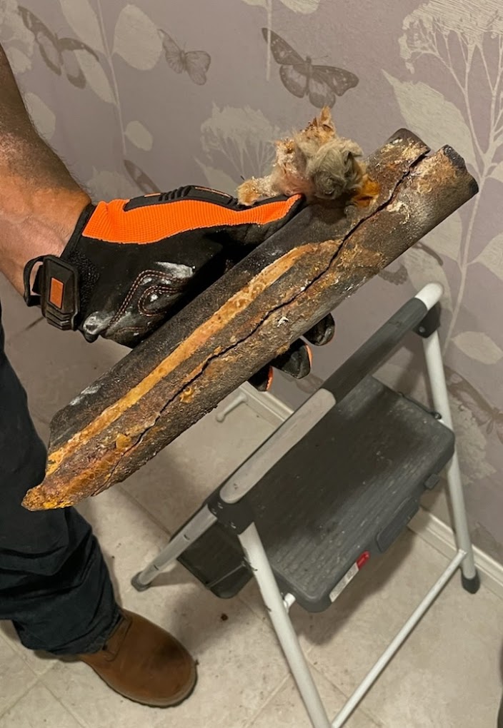 Severely corroded cast iron pipe removed from residential bathroom